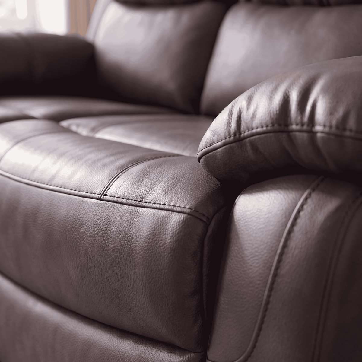 Belgravia recliner in brown, close up of the leather-look upholstery and padded arm